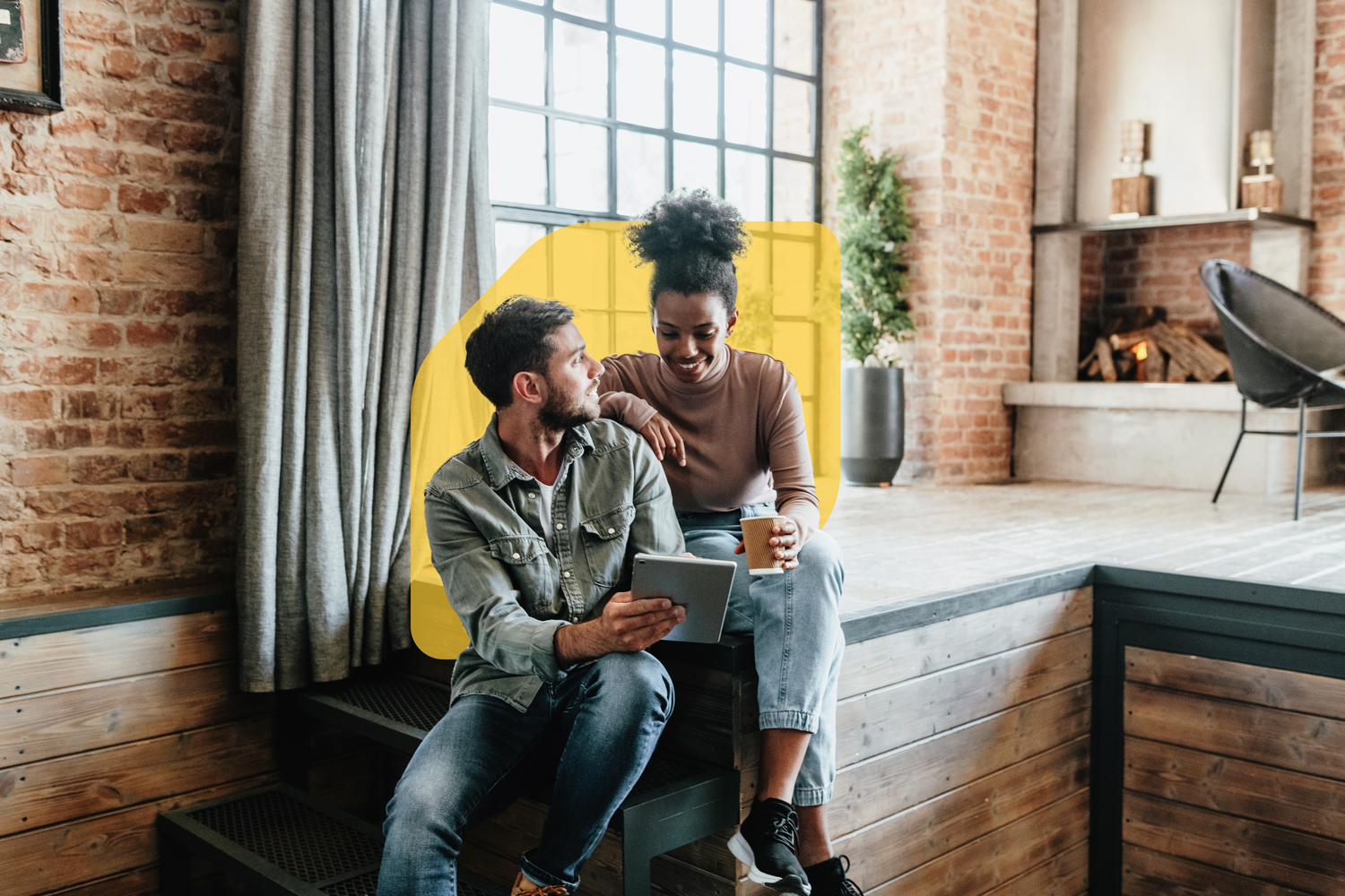 A couple sits in their home reviewing information on a tablet